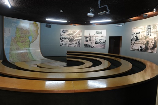 The Jewish settlement Room - tiers of seats; on the wall there’s a map of Israel and black and white historic photographs