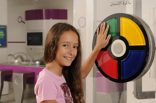 A girl smiles as she plays an interactive memory game in the museum