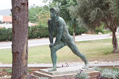   Bar-Kochva: A statue of a nude bearded man, standing with his right leg stretched forward. He is leaning with both hands on hi