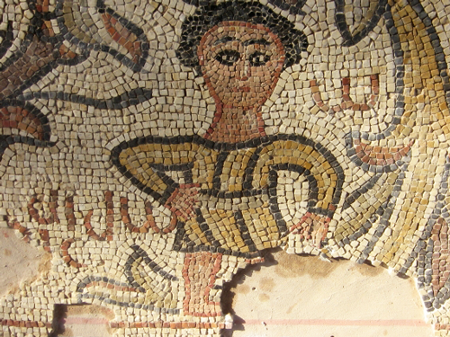 An ancient mosaic featuring a male figure and an inscription